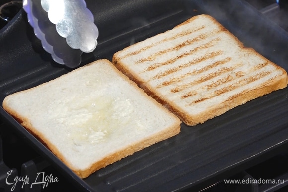На сухую, хорошо разогретую сковороду-гриль выложить хлеб. Смазать с одной стороны сливочным маслом, перевернуть, обжаривать 2–3 минуты.