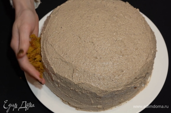 Собранный торт нужно обмазать кремом. Наносим первый тонкий слой, затем отправляем торт на 15 минут в холодильник и наносим следующий слой крема.