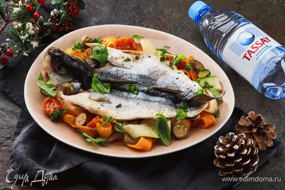Подавайте рыбу, полив соусом с овощами и украсив петррушкой и базиликом.
