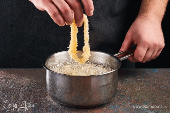 Разогрейте сковороду, налейте в нее большое количество масла. Опускайте кальмаров в кипящее масло и жарьте их чуть больше одной минуты.