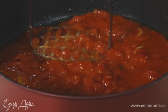 Консервированные помидоры в собственном соку добавить на сковороду, размять до однородной массы.