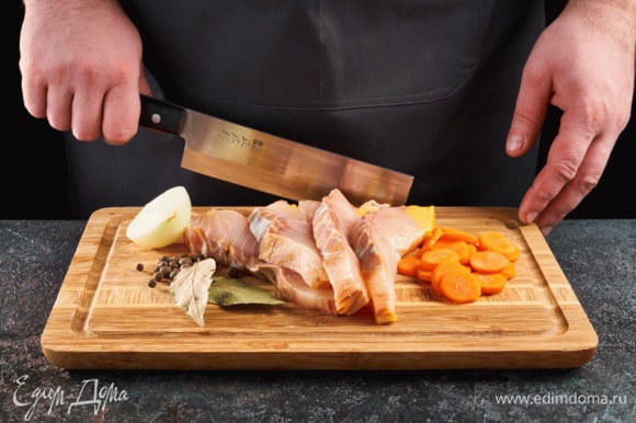 Нарежьте рыбу порционными дольками. Лук разрежьте пополам, морковь нарежьте кружочками.