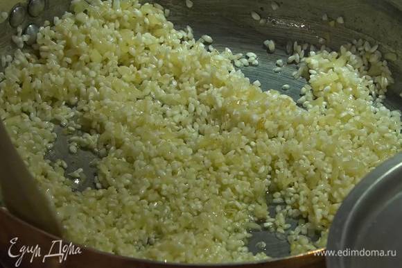 Всыпать в сковороду рис и сделать тостатуру: постоянно помешивая, прогревать в течение 1‒2 минут, пока зерна не станут прозрачными.