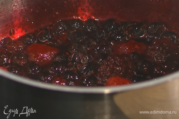 В сотейник всыпать замороженные ягоды, добавить ликер и сахар. Потомить ягоды на среднем огне в течение 5 минут. Затем снять с плиты и дать остыть.