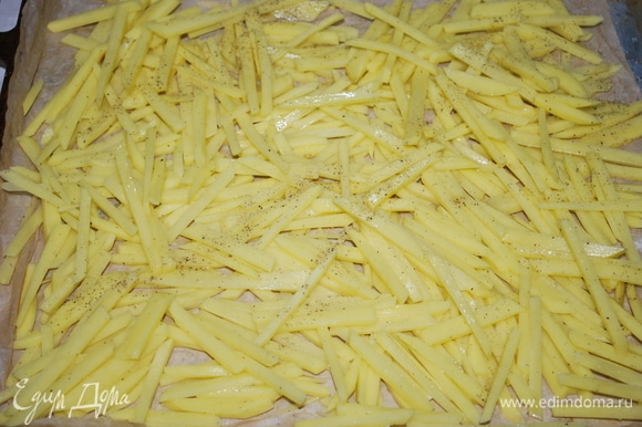 Очистите картофель и нарежьте тонкими брусками (тоньше, чем на картофель фри). Выложите на противень и запекайте в духовке 20 минут.