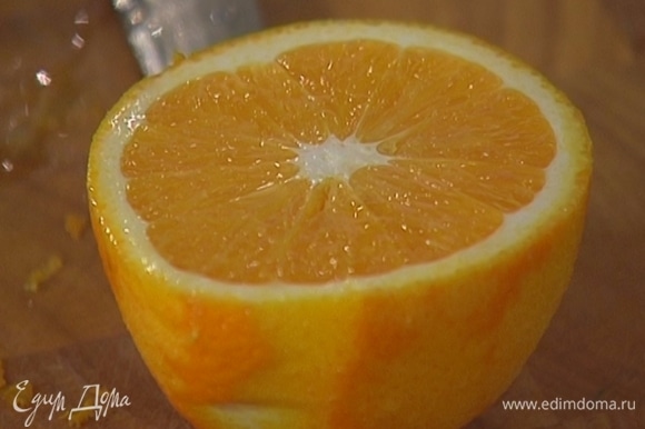 Цедру апельсина натереть на мелкой терке, затем разрезать его пополам.