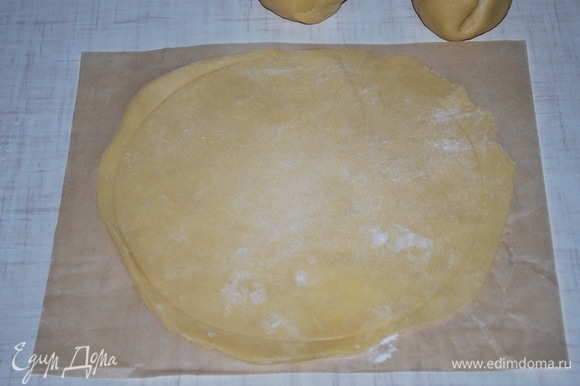 Раскатайте тесто на пекарской бумаге, присыпанной мукой. Выпекайте до золотистого цвета в разогретой духовке при 170–180°C, примерно 6–8 минут.