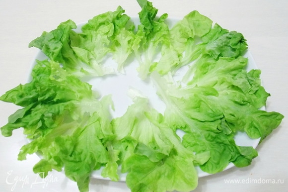 Разложим по краю блюда листья салата.