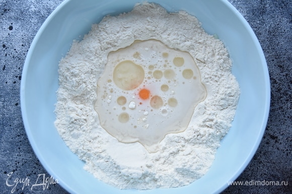 Для белого теста просеять в миску муку, сделать в центре углубление, куда влить воду, добавить уксус столовый, растительное масло, соль и яйцо.