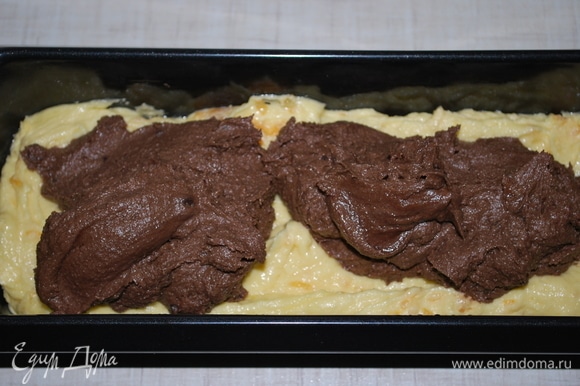 Сверху мандаринового теста распределите силиконовой лопаткой шоколадное тесто.