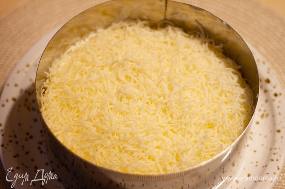 Натереть на терке яйца, выложить четвертым слоем и смазать майонезом. Затем пятый слой — посыпать сверху натертый сыр.