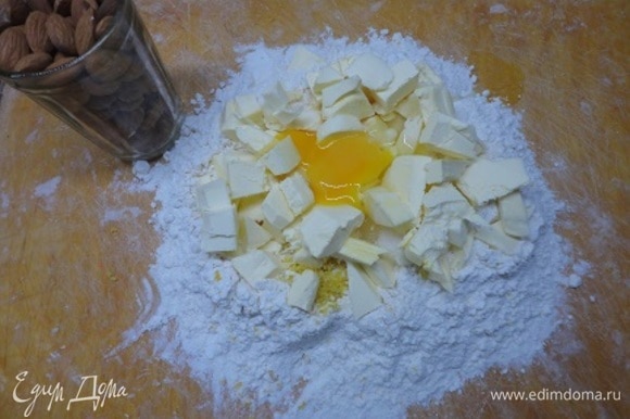 К муке добавить соль, сахар, цедру одного лимона, нарезанное кусочками холодное масло и 1 яйцо.