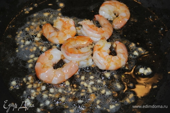 Креветки почистите от панциря и черной кишки. В сковороде разогрейте оливковое масло и добавьте мелко нарезанный чеснок и креветки. Обжаривайте примерно 2–3 минуты до готовности.