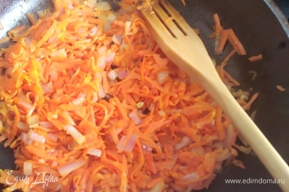 Влить на сковородку масло. Добавить тертую морковь, лук и обжарить в течение 5–7 минут, постоянно помешивая.