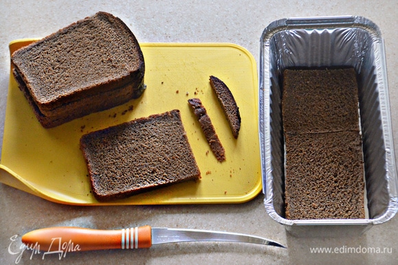С бородинского хлеба срежьте корки. Нарежьте куски хлеба по размеру формы для закусочного торта. Я использовала 2 небольшие формы для кекса.