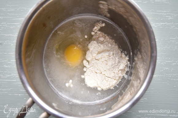 В сотейнике соединить воду, соль, яйцо и 2 ст. л. муки. Перемешать смесь венчиком, чтобы не было мучных комочков, и поставить на медленный огонь.