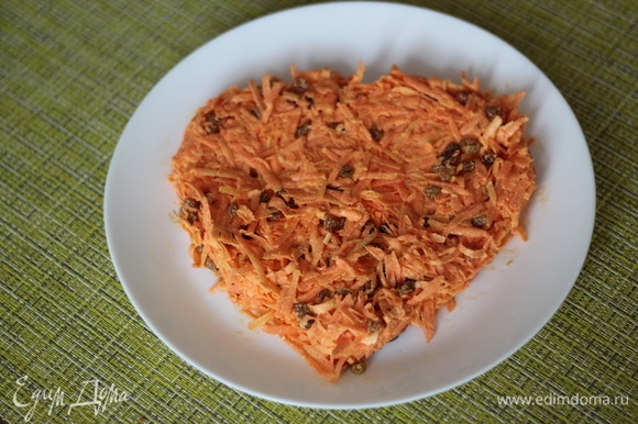На блюдо выкладываем первый слой: морковь с изюмом с чесночным майонезом. Придаем первоначальную форму сердечка.