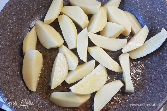 Картофель разрезать на дольки и обжарить до готовности.