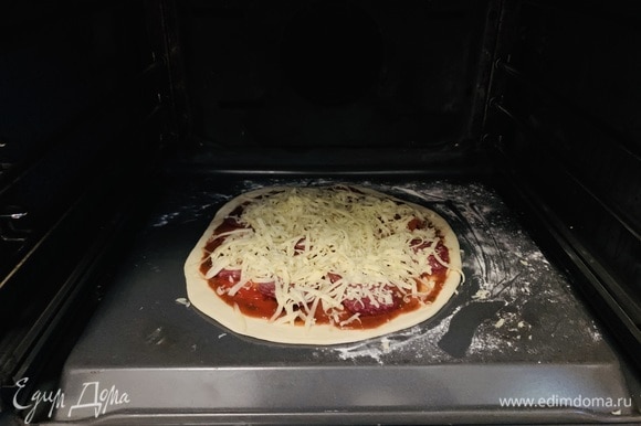 Припыляем мукой противень с обратной стороны — так пицца легко съезжает после выпекания. Можете использовать любую другую форму, непринципиально. Перекладываем на него тесто и заправляем пиццу.