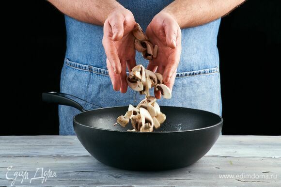 Выложите мелко нарезанный чеснок и жарьте 1 минуту, постоянно помешивая. Добавьте грибы к чесноку и обжаривайте до золотистого цвета.