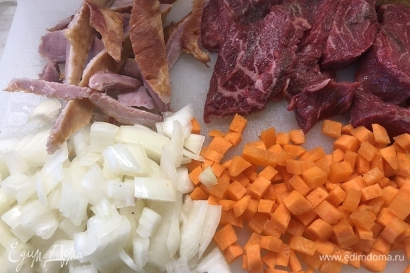 Нарежьте мясо на небольшие стейки, лук и морковь — небольшими кубиками.