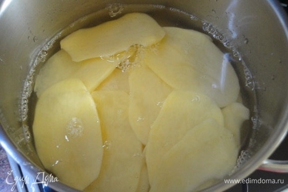 Картофель почистить и нарезать тонкими кружочками. Залить водой, довести до кипения, воду слить.