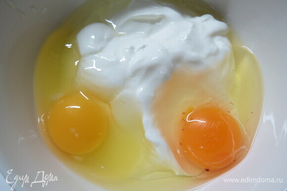 В миске соединить сметану, яйца. Все перемешать. Подсолить по вкусу, ориентируясь на соленость ветчины и сыра.