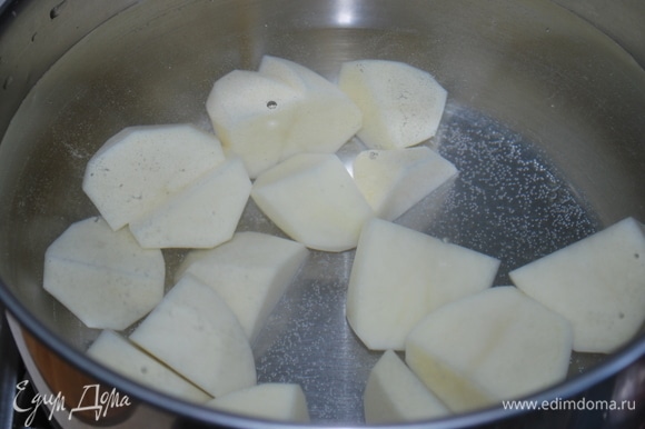 Картофель почистите, нарежьте на 4 части и поставьте вариться. Посолите по вкусу.