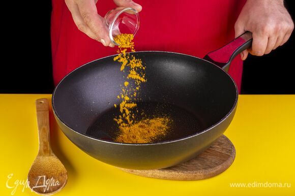 В разогретое на сковороде растительное масло добавьте карри. Хорошо перемешайте.