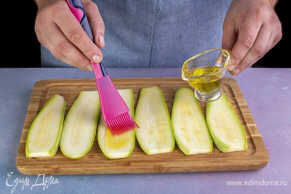 Кабачки нарежьте тонкими слайсами по всей длине. Смажьте оливковым маслом.