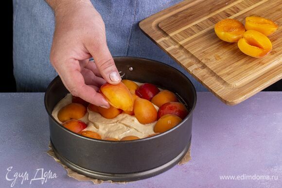 Тесто выложите в форму, застеленную пергаментом. Выложите абрикосы.