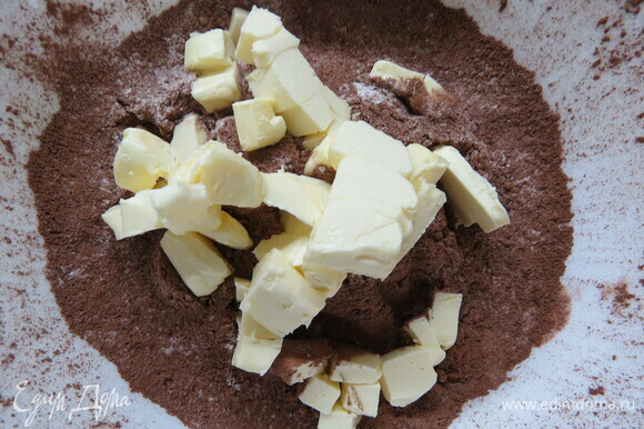 Для теста смешиваем в миске муку, сахарную пудру, какао и соль. Добавляем охлажденное и нарезанное кубиками сливочное масло и растираем смесь в крошку.