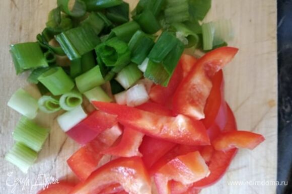 Тем временем нарезать соломкой болгарский перец и некрупно — зеленый лук.