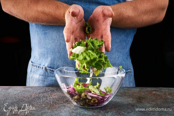 В салатник выложите салатный микс, вяленые томаты, оливки.