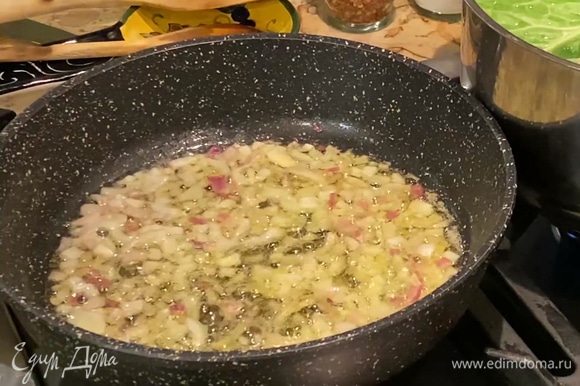 В тяжелой глубокой сковороде разогреть оливковое и сливочное масло и обжарить лук и чеснок до прозрачности.