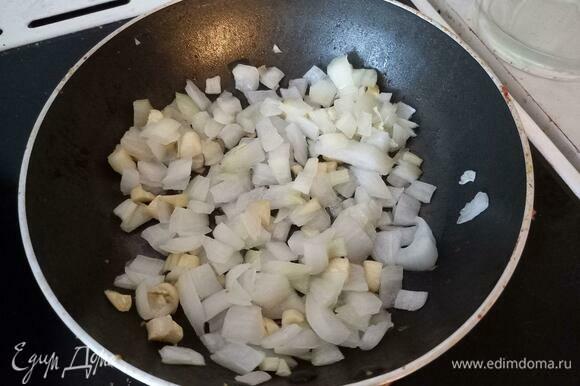 В маленькую сковороду налить подсолнечное масло, выложить измельченные лук и чеснок.