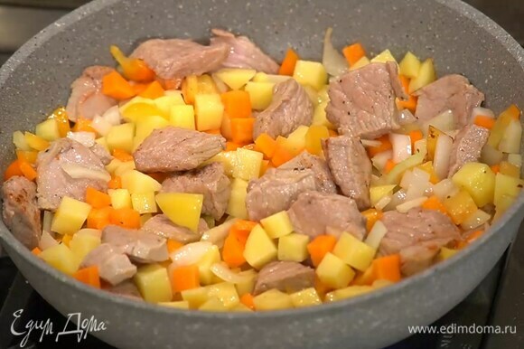 Картофель и морковь почистить, нарезать небольшими кубиками и добавить к мясу, все перемешать, посыпать смесью перца и кориандра, немного обжарить, затем влить горячий бульон.