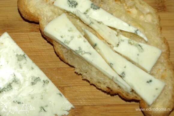 Сыр нарезать, 30 г выложить на нижнюю часть круассана.