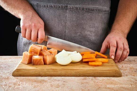 Нарежьте рыбу порционными кусочками. Лук разрежьте пополам, морковь нарежьте кружочками.