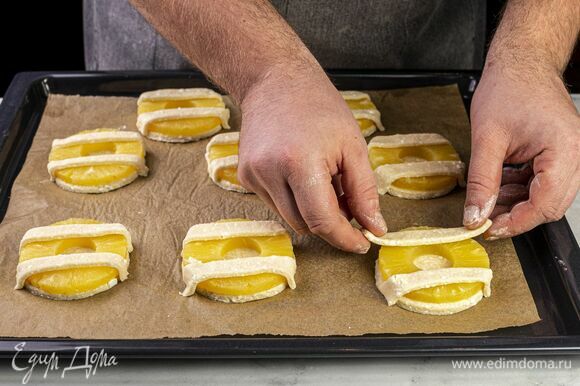 Из остатков теста сделайте красивую решетку при помощи кулинарного валика. Выложите поверх ананасов и прижмите снизу.