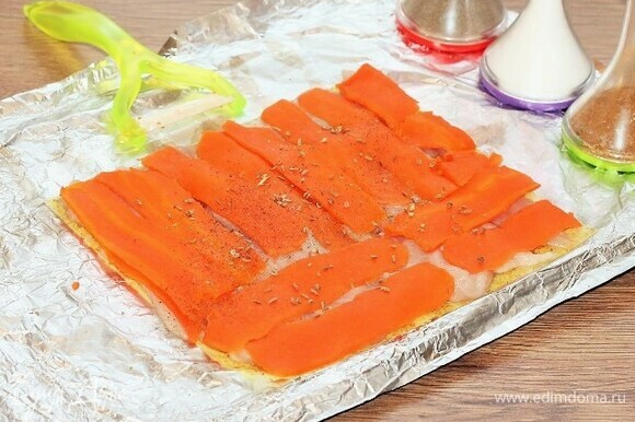 Вареную морковь с помощью овощечистки нарезаем длинными пластинами и выкладываем на курицу, посыпаем приправой для овощей, перцем и солью.