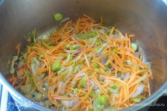 К луку добавить морковь и томить, помешивая, еще 3–4 минуты.