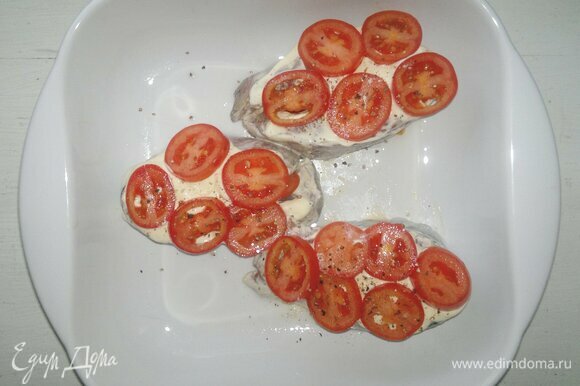 Выложить на стейки оставшуюся сметану, разложить кружки помидоров, немного поперчить.