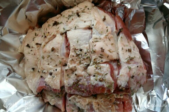 Достать мясо из холодильника. Завернуть свинину в два слоя фольги, выложить на противень и поставить в духовку, разогретую до 180°C , на 1 час.