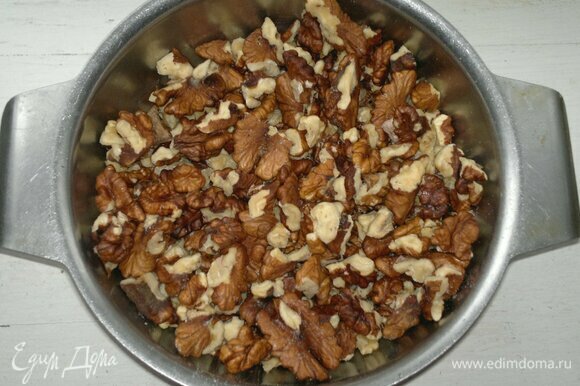 Грецкие орехи порубить в крупную крошку. Для украшения оставить половинку грецкого ореха.