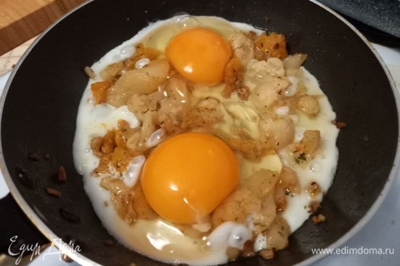 Аккуратно разбиваем два яйца поверх овощей, стараясь не повредить желток, в таком виде яичница-глазунья будет еще симпатичнее. Накрываем крышкой, чтобы белок лучше схватился, на 1–2 минуты, но желток при этом должен оставаться сырым.