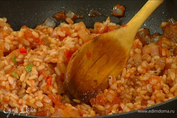 Рис отварить до полуготовности и выложить в сковороду с томатной массой, добавить чили, измельченную зелень, все поперчить и перемешать.