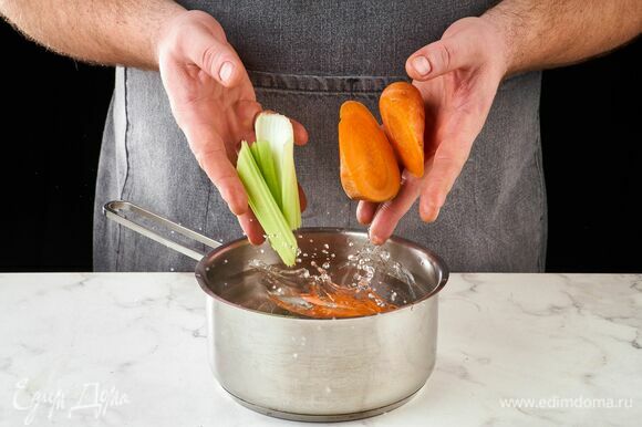 Морковь и сельдерей крупно нарежьте. Положите в кастрюлю с горячей водой.