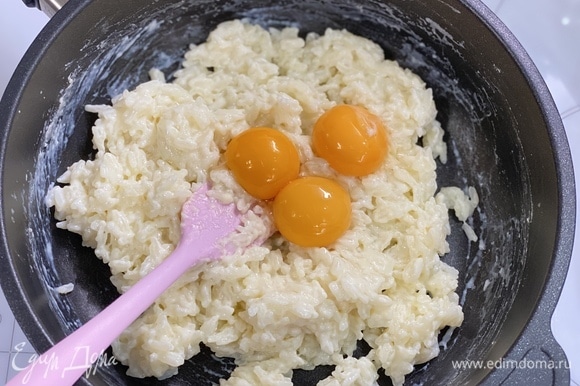Желтки отделить от белков и добавить к рису. Перемешать.