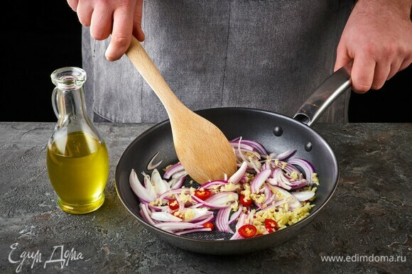 На сковороде обжарьте в оливковом масле имбирь, перец чили и лук.